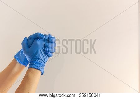 Hands In Blue Medical Glove On White Background. One Hand Holds The Other. Protection Against Pandem