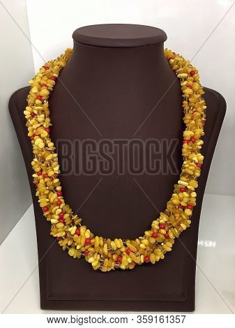Handmade Amber Bead Necklaces In A Shop Window. Template For Decorating A Jewelry Store And A Salon 