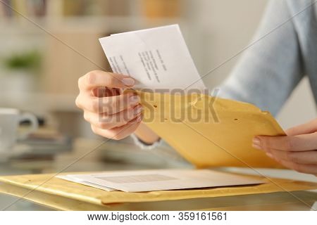 Close Up Of Woman Hands Opening A Letter On A Padded Envelope On A Desk At Home