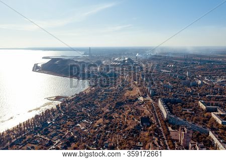 Industrial City In Summer. On The Horizon, A Metallurgical Plant Near The Sea