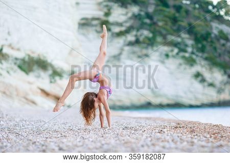 Adorable Active Little Girl At Beach During Summer Vacation