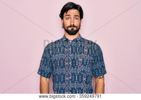 Young handsome hispanic bohemian man wearing hippie style over pink background puffing cheeks with funny face. Mouth inflated with air, crazy expression.
