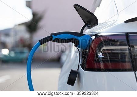 Ev Electric Car Pluged Charging At A Recharge Station In The City