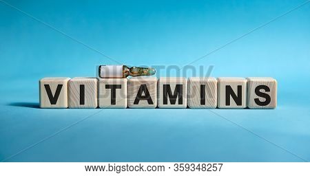 Vitamins - Word On Cubes. Drug In Ambula To Reduce Disease Symptoms On A Blue Background