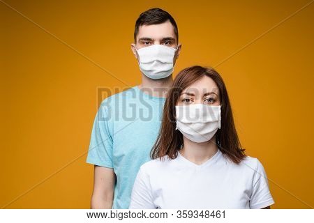 Young Couple In Aseptic Masks. Studio Stock Photo Of Man And Woman