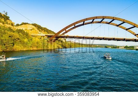 Boats Floating Down The Colorado River Under The 360 Bridge Or Pennybacker Bridge Of Austin , Texas 