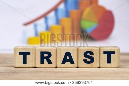 The Concept Of The Word Trast On Cubes Against The Background Of The Graph