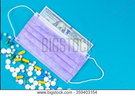 Coronavirus Wuhan. Us Quarantine, 100 Dollar Banknote With Medical Mask With Pills. The Concept Of E