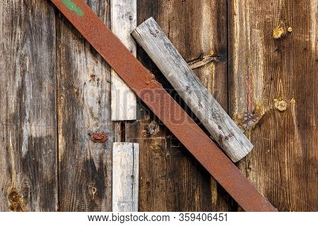 Wooden Doors Are Closed With A Rusty Metal Strip.