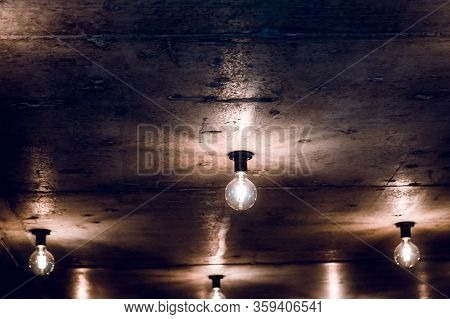 An Electric Lamp Shines On A Brown Background On The Ceiling.