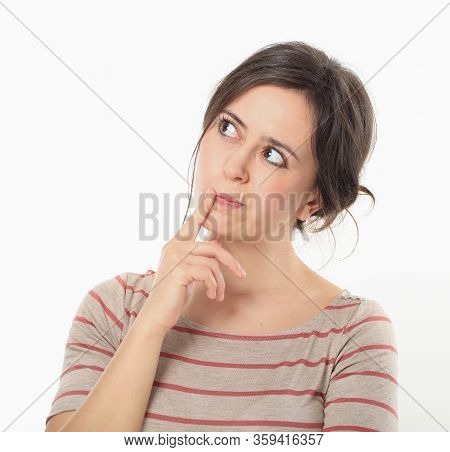 Thinking Young Woman Holding Forefinger At Her Lips