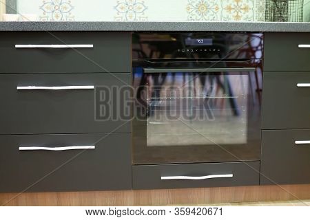 Built-in Oven In The Kitchen Countertop. Built-in Appliances In The Kitchen. Cabinets Are Gray, Blac