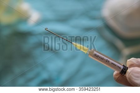 Close Up Shot Of A Syringe With The Word Coronavirus Vaccine.the Hand Holding It Is Pressing The Plu