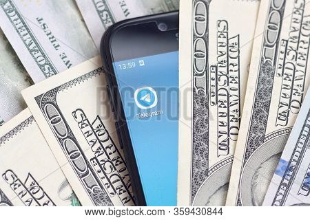 Smartphone Screen With Telegram App And Lot Of Hundred Dollar Bills. Business And Social Networking 