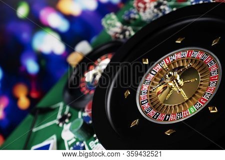 Roulette Table In Casino. Casino Felt Green Table With Red And Black Numbers. Stack Of Poker Chips.