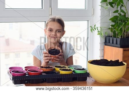 Cheerful Girl Holding A Pot Of Land For Planting Plants And Looked Into The Frame