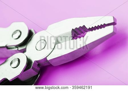 Multitool Is A Multi-functional Tool On A Pink Background. The Concept Of An Open, Flying Multi-tool