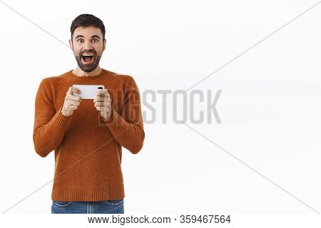 Technology, Online And People Concept. Portrait Of Enthusiastic Upbeat, Handsome Bearded Male Playin