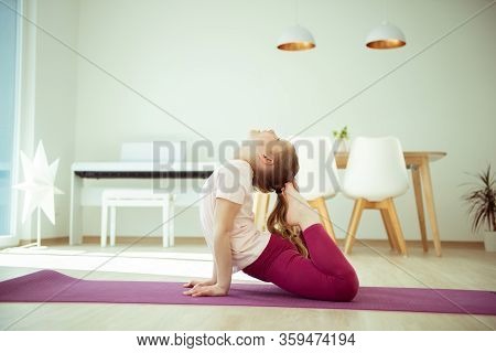 Pretty Happy Child Girl Having Fun Making Yoga Exercises At Home During Coronavirus Quarantine
