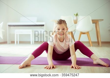 Pretty Happy Child Girl Having Fun Making Yoga Exercises At Home During Coronavirus Quarantine