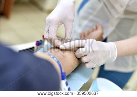 Taking Venous Blood From A Patient In A Laboratory. Puncture Step Of Skin And Vein With A Vacutainer