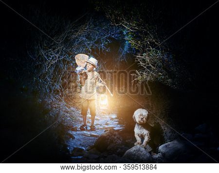 A Young Naturalist Catched Something Into A Jar. At Dark The Boy Walks Out Of A Cave With A Lantern 