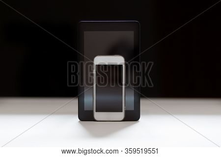 Tablet And Mobile Phone On Black Background With Black Screens.