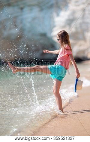Adorable Active Little Girl At Beach During Summer Vacation