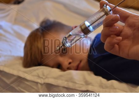 The Boy Is Afraid Of Injections. The Pediatrician With A Syringe. Baby Medical Syringe. Compulsory T