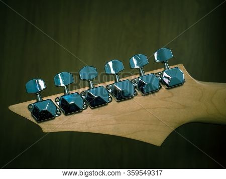 Guitar Head With Silver Tuning Pegs Or Keys. Close Up With Tuners Or Machine Heads Of A Guitar.