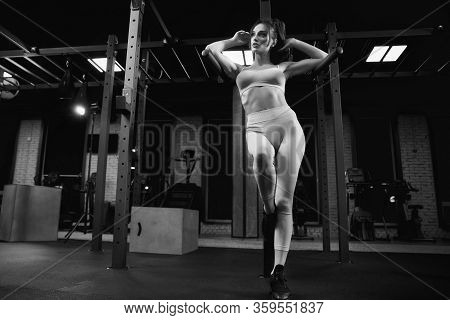 From Above View Of Female Bodybuilder Leaning On Parallel Bars. Srtong Woman With Perfect Body Posin
