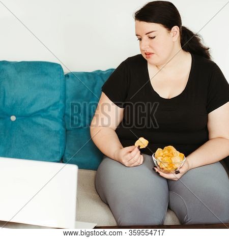Mindless Snacking, Home Sedentary Lifestyle, Compulsive Overeating. Obese Lazy Woman Sitting On Sofa