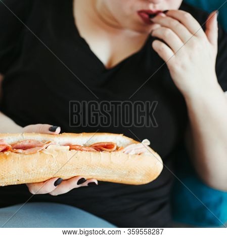 Overeating And Gluttony Concept. Mindless Snacking, Home Sedentary Lifestyle. Obese Woman Sitting On