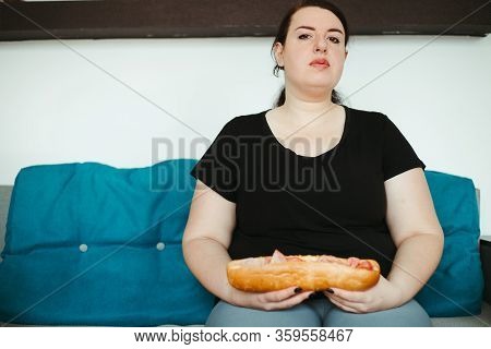 Mindless Snacking, Home Sedentary Lifestyle, Compulsive Overeating. Obese Woman Sitting On Sofa Eati