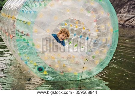 Cute Little Boy, Playing In Zorb A Rolling Plastic Cylinder Ring With A Hole In The Middle On The La