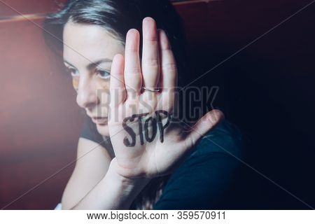 Young Girl, Victim Of Abuse Cover Herself With Her Hand In Whose Open Palm The Word Stop Is Written