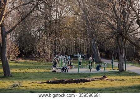 London, Uk - March 22,2020: People Exercise At An Outdoor Gym Inside Broomfield Park, Public Park In