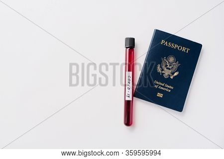 Travel Restrictions, Quarantine And Coronavirus Concept. Blood Sample In Tube And Passport On White 