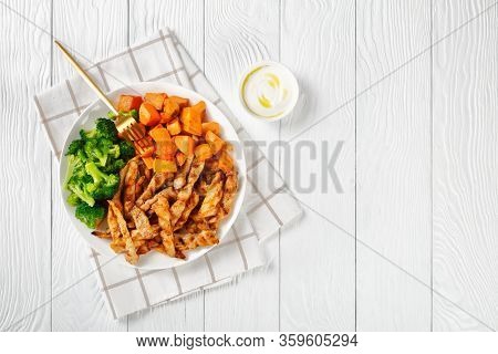 Low-calorie Meal: Sweet Potato, Roasted Chicken And Broccoli On A White Plate On A White Wooden Tabl