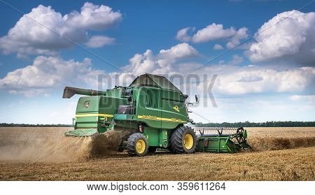 Dobrich, Bulgaria - July 08: Modern John Deere Combine Harvesting Grain In The Field Near The Town D