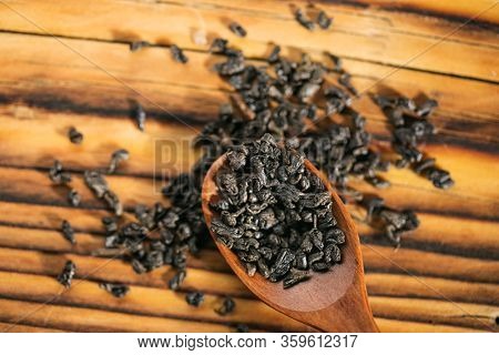 Dry puer tea leaf in wooden spoon on the rustick table