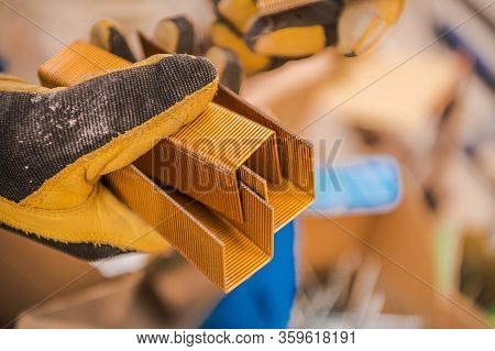 Heavy Duty Power Stapler Gun Metal Staples In Contractors Hand. Construction Industry Equipment.