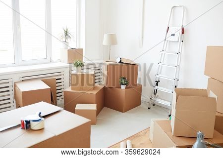 Wide Angle Background Of Stacked Cardboard Boxes In Empty White Room, Moving, Relocation And House D