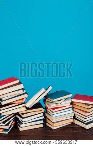 Many Stacks Of Educational Books For Learning Preparation For College Exams On A Blue Background