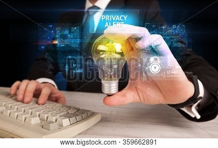 Businessman holding lightbulb with PRIVACY ALERT inscription, online security idea concept