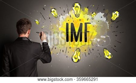 businessman drawing colorful light bulb with IMF abbreviation, new technology idea concept