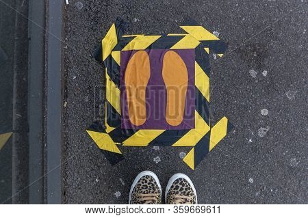 A Close Up View Of A Marked Off Area Outside A Shop Or Supermarket Where You Need To Stand Due To Th