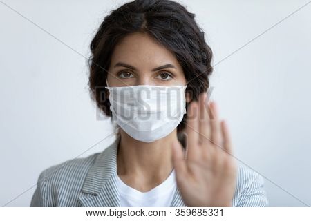 Worried Young Woman In Protective Facemask Showing Stop Sign.