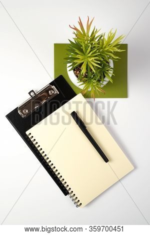 Desktop View From The Top With Stationery, Notepad And Flower, A Concept For Business, Environmental