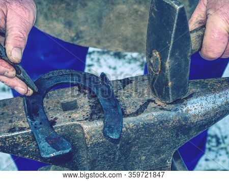 Creating Holes In Horseshoes. Smith Hand Beats The Horseshoe Hammer And Piercer.